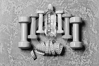Barbells, colorful tape measures and water bottle placed in pattern Stock Photo
