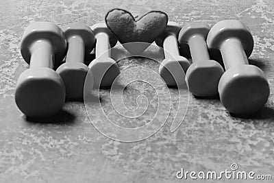 Barbells in different colors and heart placed in pattern, closeup Stock Photo