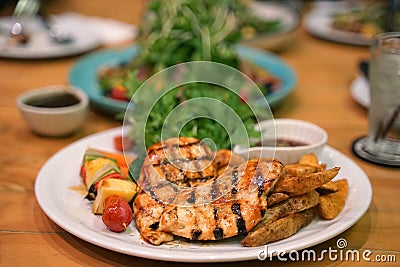 Barbeque grilled chicken breast and fried potato chip serving with fresh salad Stock Photo
