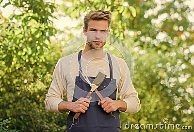 Barbeque party. Picnic concept. Bbq chef. Handsome guy cooking food. Cooking burgers. Man hold barbeque equipment Stock Photo