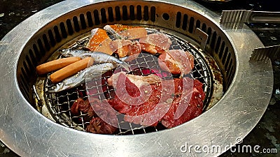 Barbeque with salmon, fish, pork, beef, sausage on stove at Korea restaurant. Stock Photo