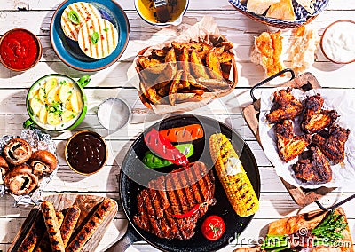 Barbequed Meats and Vegetables on Picnic Table Stock Photo