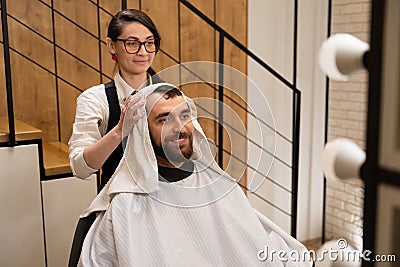 Barber dries the hair of the client with soft towel Stock Photo