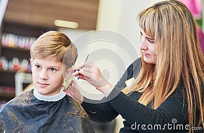 Barber or hair stylist at work. female hairdresser cutting child hair Stock Photo