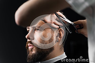 Barber making hairstyle for confident bearded hipster. Advertising for barbershop and men& x27;s beauty salon. Stock Photo