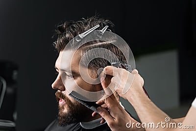 Barber making hairstyle for confident bearded hipster. Advertising for barbershop and men& x27;s beauty salon. Stock Photo