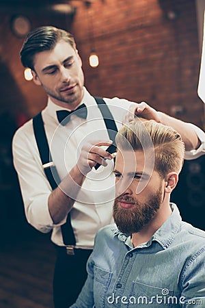 Barber shop classy dressed handsome stylist is doing a perfect h Stock Photo