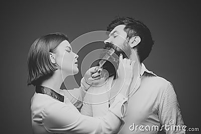 Barber shop. Hair style. Barbershop or hairdresser concept. Woman hairdresser cuts beard with scissors. Man with long Stock Photo