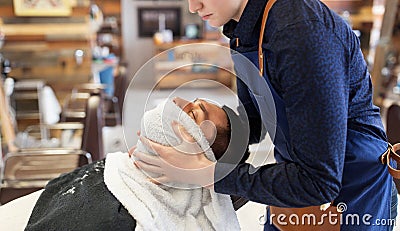Barber softening male face sking with hot towel Stock Photo
