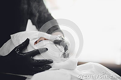 Barber steam face skin of man with hot towel before royal shave in Barbershop Stock Photo