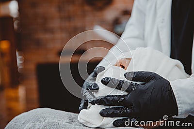 Barber steam face skin of man with hot towel before royal shave in Barbershop Stock Photo