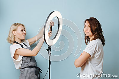 Barber woman is taking photo of a client with the help of ring lamp Stock Photo