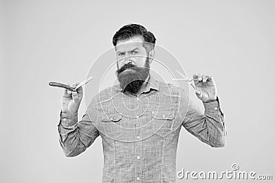 Barbershop offer range of packages for groom. Bearded man work in barbershop. Hipster hold barber tools yellow Stock Photo