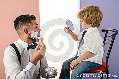 Barbershop. Trendy and stylish father and son. Barber shaving a bearded man in a barber shop. Barber Shop Studios Stock Photo