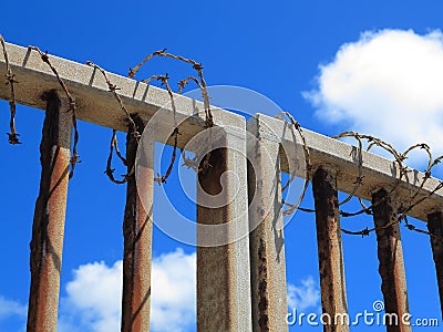 Barbwire wound around metal fence Stock Photo