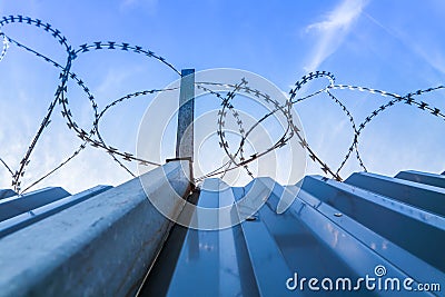 Barbwire protection fence with blue sky Stock Photo