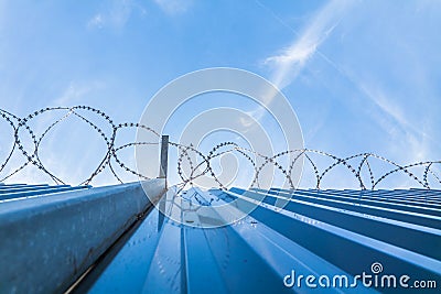 Barbwire protection fence with blue sky Stock Photo