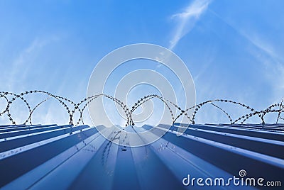 Barbwire protection fence with blue sky Stock Photo