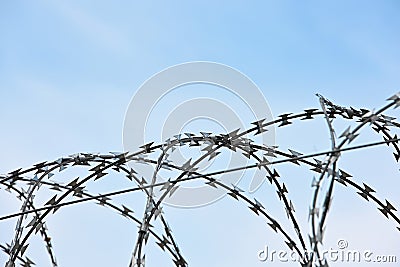 Barbwire security rolls protection over blue sky Stock Photo