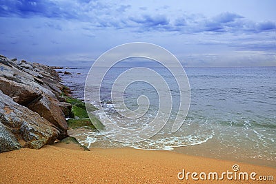 Barcelona beach with some waves breaking against the rocks at sunrise. Empty copy space Stock Photo