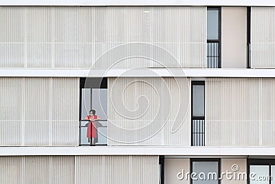 BARCELONA - JUNE 28: Lonely woman standing on a balcony of a modern building facade, on June 28, 2018 in Barcelona Editorial Stock Photo