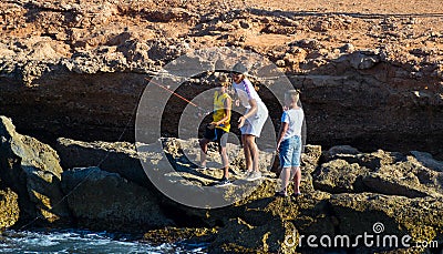 Barcelona, Spain, August 22, 2019: Three Brothers have fun fishing at the beach Editorial Stock Photo