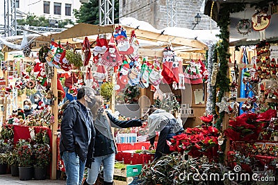 Barcelona, Spain â€“ December 20, 2021: Christmas market on the square in front of Cathedral in Barcelona, couple in the mask sele Editorial Stock Photo