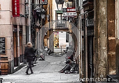 Barcelona Spain, downtown alley, narrow street, woman sitting on the ground Editorial Stock Photo