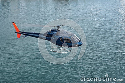 Blue helicopter flying over the city of Barcelona. Aerospatiale AS 355F-2 Ecureuil 2 Editorial Stock Photo