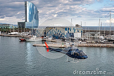 Blue helicopter flying over the city of Barcelona. Aerospatiale AS 355F-2 Ecureuil 2 Editorial Stock Photo