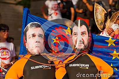 Barcelona, spain- 17 july 2019: young activists march holding rubber dinghy with european union flag and Matteo Salvini and Pedro Editorial Stock Photo