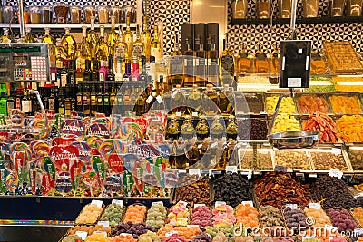 BARCELONA, SPAIN - MAY 16, 2017: Sale of different sweets, dry fruits, oils and other products on the famous La Boqueria market in Editorial Stock Photo