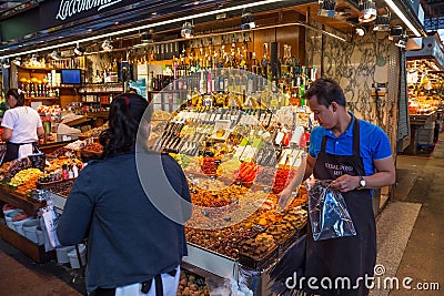 BARCELONA, SPAIN - MAY 16, 2017: Sale of different sweets, nuts, dry fruits and vegetables, oils and other products on the famous Editorial Stock Photo