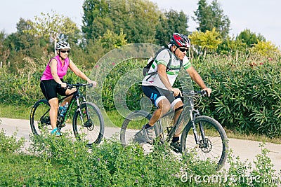 A pair of Mature cyclists on a walk in the Park Editorial Stock Photo