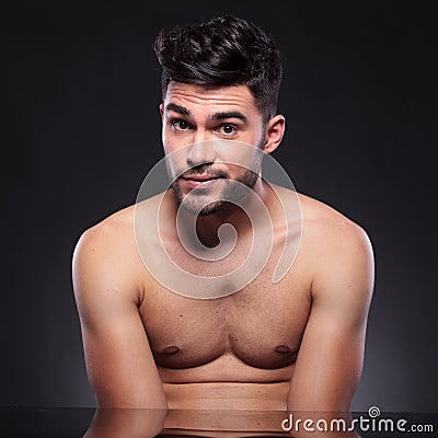 Bare chest young man raises his eyebrows Stock Photo