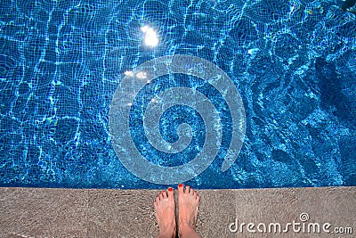 Bare feet on the edge of the swimming pool Stock Photo
