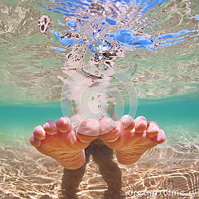 Bare foot child on beach vacation. Underwater photo Stock Photo