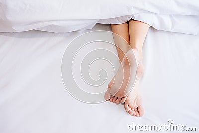 Woman foot on the bed. Stock Photo
