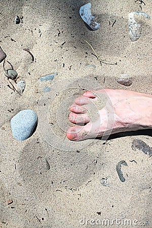 Bare male foot on the sand. Beach vacation. A foot in the sand Stock Photo
