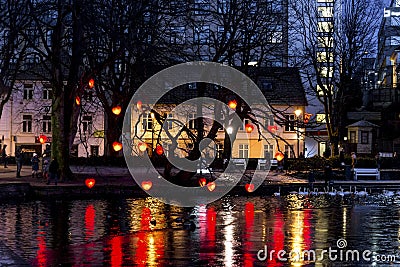 Bare trees decorated with lighted red hearts for Christmas festive season at Stavanger city park lake at night Editorial Stock Photo