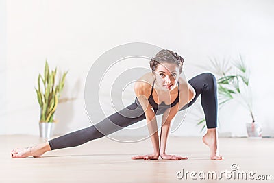 Barefoot elegant Caucasian ballerina doing stretching exercise standing on tiptoe in side lunge position looking at Stock Photo
