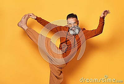 Barefoot funny bearded man in sportswear doing leg stretching Stock Photo