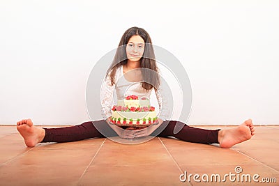 Pretty girl with anniversary cake sitting on floor Stock Photo