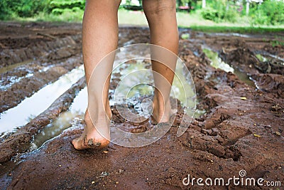 Barefoot through muddy road Stock Photo