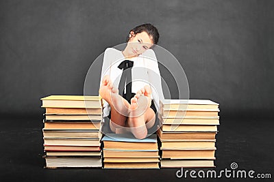 Soles of bare feet of teenage girl on top of old books Stock Photo