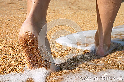 Barefoot in surf on sand coast Stock Photo