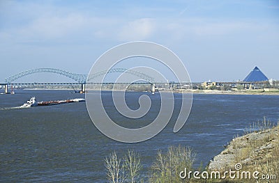 Barge on Mississippi River with Bridge and Memphis, TN in background Stock Photo