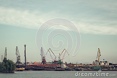 A barge in the river port and working cranes Editorial Stock Photo