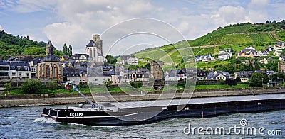 Barge traveling past medieval village on the Rhine River Editorial Stock Photo