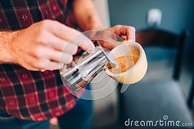 Professional barista and bartender pouring latte foam over coffee, espresso and creating a perfect cappuccino Stock Photo